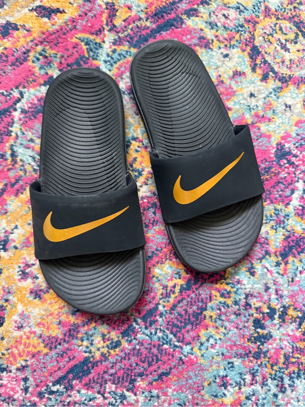 Nike Black Slides with Gold Swoosh Accent